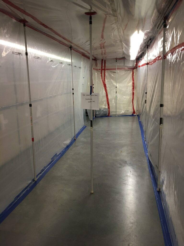Plastic sheeting containment set up in an unfinished basement
