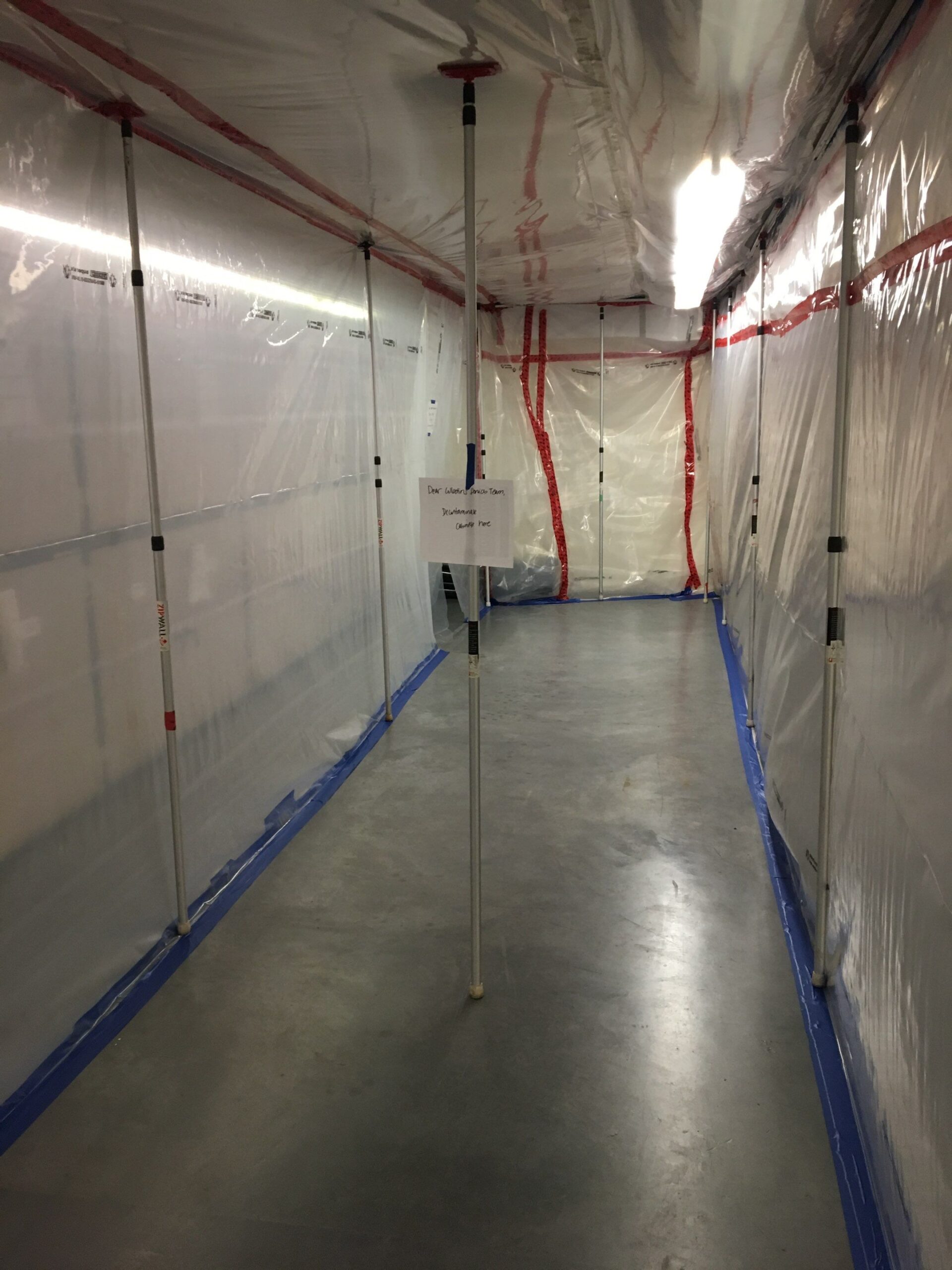 Plastic sheeting containment set up in an unfinished basement