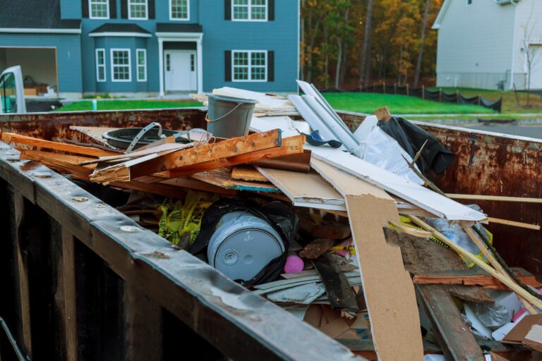 Dumpster filled with construction debris outside a house